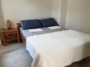 1 Schlafzimmer mit 2 Betten mit blauen Kissen und einem Tisch in der Unterkunft Nea Epidavros view in Nea Epidavros