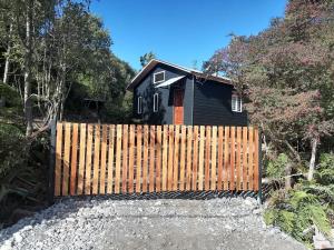 a wooden fence in front of a house at Cabaña CyG 2 - Chaitén in Chaitén