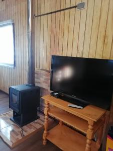 a flat screen tv sitting on a table next to a stove at Cabaña CyG 2 - Chaitén in Chaitén