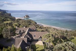 an aerial view of a house and the ocean at Hillbrook Estate Whangamata in Opoutere