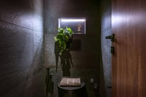 a bathroom with a toilet and a plant at Alsus Boutique Hotel - Adults Only in Amoudara Herakliou