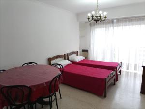 1 dormitorio con 2 camas, mesa y lámpara de araña en Departamento en Mar del Plata Zona Centro Luminoso en Mar del Plata