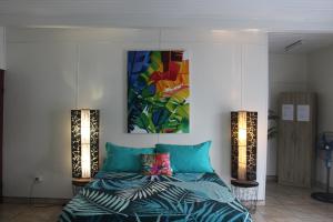 una camera da letto con un letto e un dipinto sul muro di HIME LODGE a Papeete