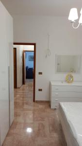 ポリニャーノ・ア・マーレにあるCasa Angyのベッドルーム1室(ベッド1台、ドレッサー、鏡付)