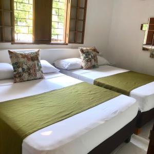 two beds sitting in a room with windows at La 10B in Cartagena de Indias
