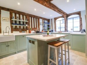 una cocina con armarios verdes y una gran isla en The Bridewell en Woodbridge