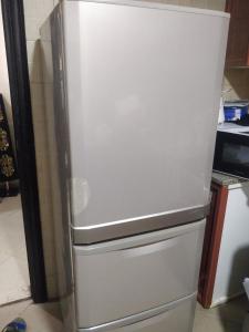 a white refrigerator freezer sitting in a kitchen at Furnished Apartment in Dubai