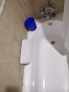 a white bath tub with a blue bowl in a bathroom at Furnished Apartment in Dubai