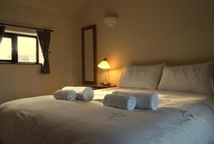 1 dormitorio con 1 cama blanca grande y toallas. en The Calf Cotts, en Leominster