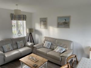a living room with two couches and a coffee table at Lees Plaice - Part of the The Bay Filey Holiday Village with pool, gym and direct beach access, pub, restaurant, tennis and meadows walks in Filey