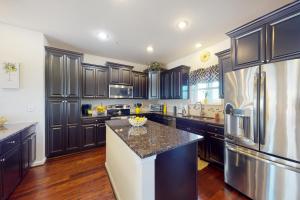 a large kitchen with black cabinets and a refrigerator at The Sand Bar at Seaside Village in Ocean City
