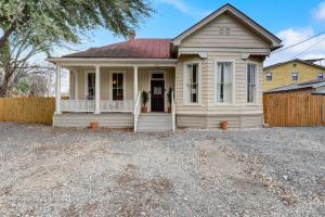 a white house with a porch and a fence at Little Lavaca #1 in San Antonio