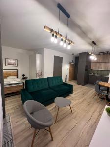 a living room with a green couch and a table at Apartament WARSZAWA Kolejowa HUB EXPO in Warsaw