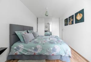 - une chambre avec un lit et une couette verte dans l'établissement Appartement design La Petite Europe - Idéal Curistes, à Vichy