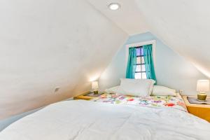 a bedroom with a white bed and a window at Tiny Blue Ridge Gem in Arden