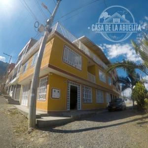 a yellow building with a car parked in front of it at CASA DE LA ABUELITA in Choachí
