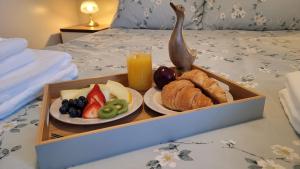 a tray of fruit and bread and a glass of orange juice at Puddleduck Cottage - Part of the The Bay Filey Holiday Village with pool, gym and direct beach access, pub, restaurant, tennis and meadows walks in Filey