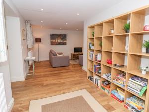 a living room with bookshelves and a couch at The Dower House Cottage in Carthorpe