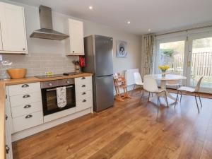 a kitchen and dining room with a table and a refrigerator at The Dower House Cottage in Carthorpe