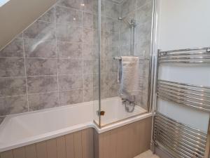 a bathroom with a shower and a bath tub at The Dower House Cottage in Carthorpe +16 photos