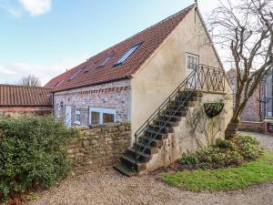 an old building with a staircase on the side of it at The Dower House Cottage in Carthorpe