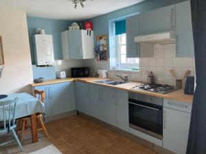 凱恩舍姆的住宿－Welford Apartments - Keynsham，厨房配有白色橱柜、水槽和窗户。