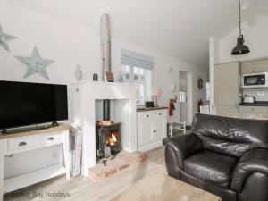 a living room with a couch and a fireplace at Sea-Renity - Part of the The Bay Filey Holiday Village with pool, gym and direct beach access, pub, restaurant, tennis and meadows walks in Filey