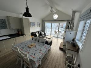 a kitchen and a living room with a table and chairs at Sea-Renity in Filey