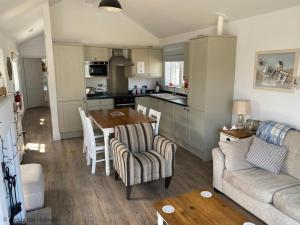 a kitchen and living room with a table and chairs at Sandy Bay Hideaway - Part of the The Bay Filey Holiday Village with pool, gym and direct beach access, pub, restaurant, tennis and meadows walks in Filey