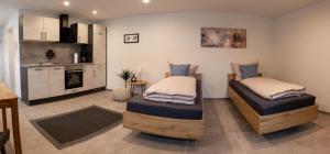 two twin beds in a room with a kitchen at Apartment Alte Raiffeisenkasse Rothenburg ob der Tauber in Rothenburg ob der Tauber