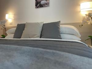 a bedroom with a bed with pillows on it at Hotel Augustus in Milano Marittima