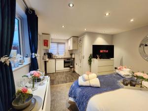 een kleine kamer met een bed en een keuken bij Studio Apartment The Den Colnbrook in Colnbrook