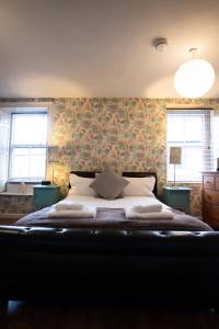 a bedroom with a bed and two windows at Laburnum Guest House at Bistro En Glaze in Wylam
