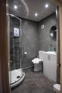 y baño con ducha, aseo y lavamanos. en Laburnum Guest House at Bistro En Glaze, en Wylam
