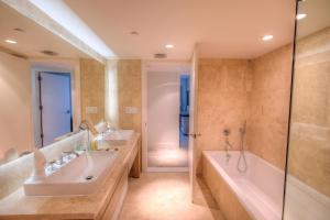 een badkamer met 2 wastafels, een bad en een douche bij Oceanview Private Condo at 1 Hotel & Homes -1211 in Miami Beach