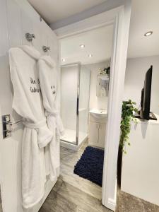 a bathroom with white towels hanging on a door at Studio Apartment The Den Colnbrook in Colnbrook
