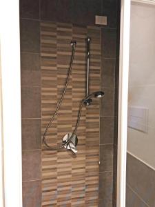 una doccia con tubo sul pavimento piastrellato di Appartamento Il Gelsomino a Castelleone