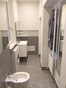 bagno con servizi igienici bianchi e lavandino di Appartamento Il Gelsomino a Castelleone