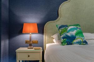 a bedroom with a bed with a lamp on a table at Palazzo Bifora Mdina in Mdina