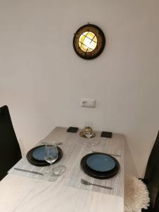 un tavolo con due bicchieri da vino e un orologio sul muro di Tiny Home mit Panoramaterrasse - Ausblick ins Grüne inklusive a Wilhelmshaven