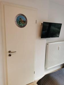 una porta bianca con una TV a muro di Tiny Home mit Panoramaterrasse - Ausblick ins Grüne inklusive a Wilhelmshaven