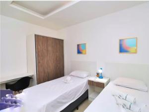 1 dormitorio con 2 camas y escritorio con silla en Rio Flat Copacabana Beach, en Río de Janeiro