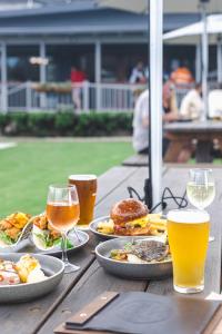 a wooden table with plates of food and glasses of beer at Royal Hotel Kew in Kew