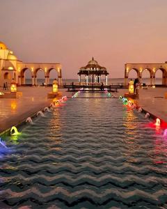 a pool of water in front of a building with a gazebo at Palm Beach Piazza Apart hotel Sahl Hasheesh in Hurghada