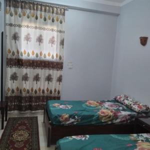 a room with two beds and a curtain at Habou City Apartment in Luxor