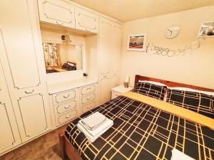 a bedroom with a bed with a black and white comforter at EEE Home Away From Home Dudley 