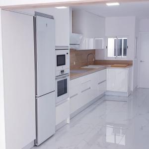 een witte keuken met een koelkast en een wastafel bij ENZO SUITE in Las Palmas de Gran Canaria