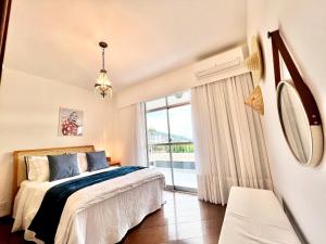 a bedroom with a bed and a large window at Jacarepaguá Residence - Quarto em apartamento in Rio de Janeiro