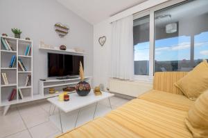 uma sala de estar com uma cama e uma televisão em City Melody Apartment with Private Parking em Alexandroúpolis