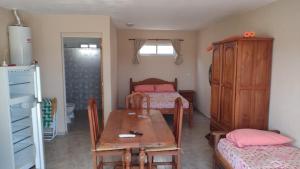een kleine kamer met 2 bedden, een tafel en een eetkamer bij Vista del Lago in Villa Carlos Paz